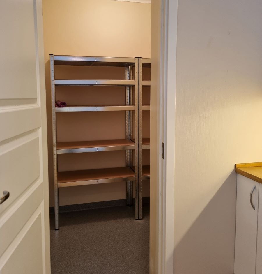 Praktisk bod med to hyllereoler, innenfor kjøkkenet.